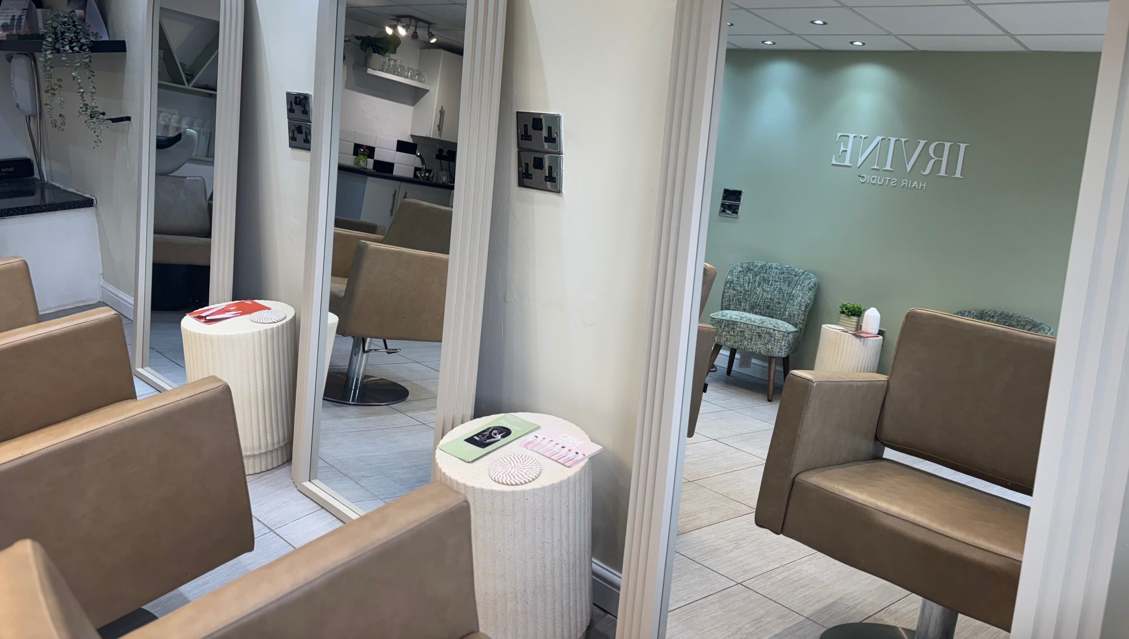 Interior view of Irvine Hair Studio in Bolton, England, GB, showcasing modern styling chairs and large mirrors.