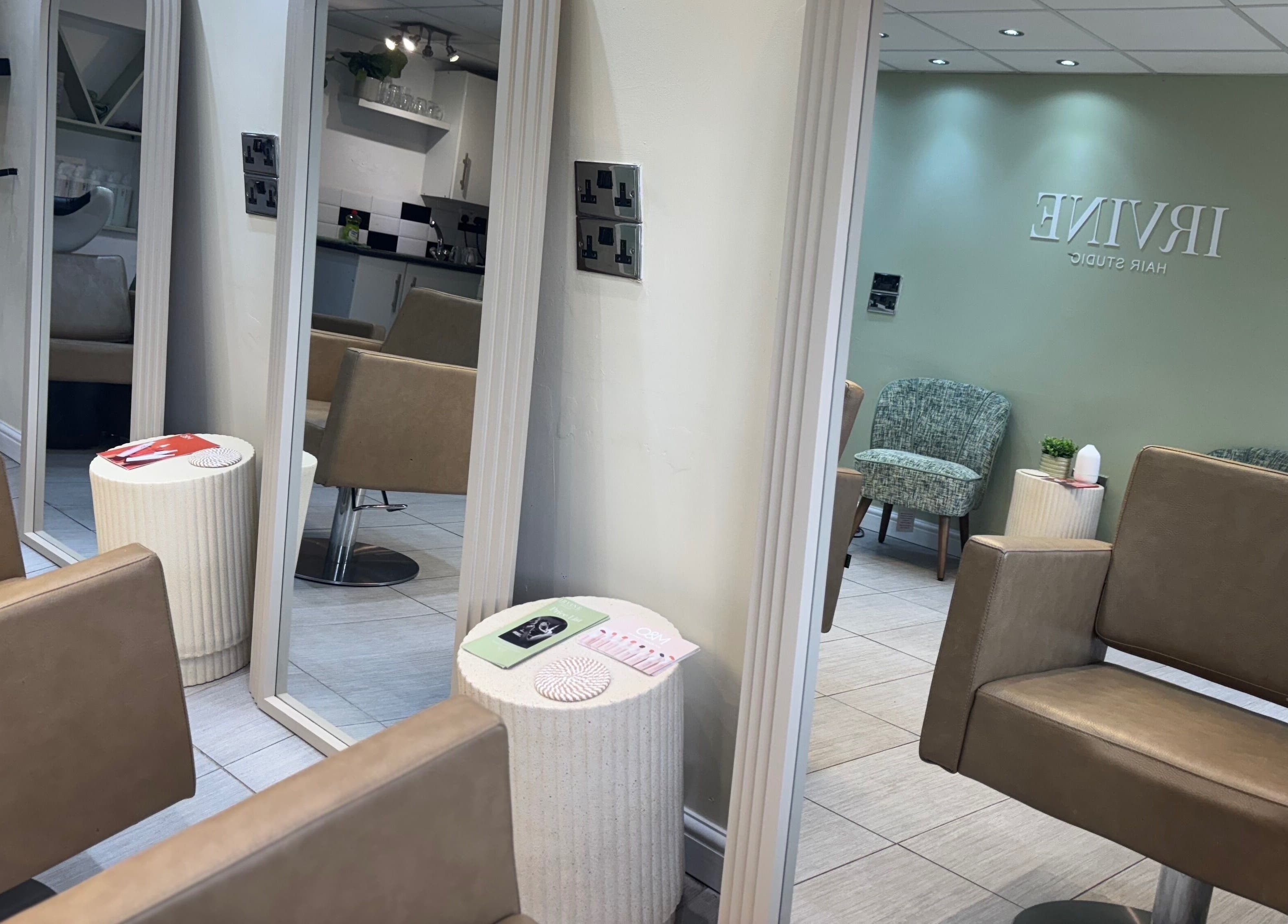 Interior view of Irvine Hair Studio in Bolton, England, GB, showcasing modern styling chairs and large mirrors.