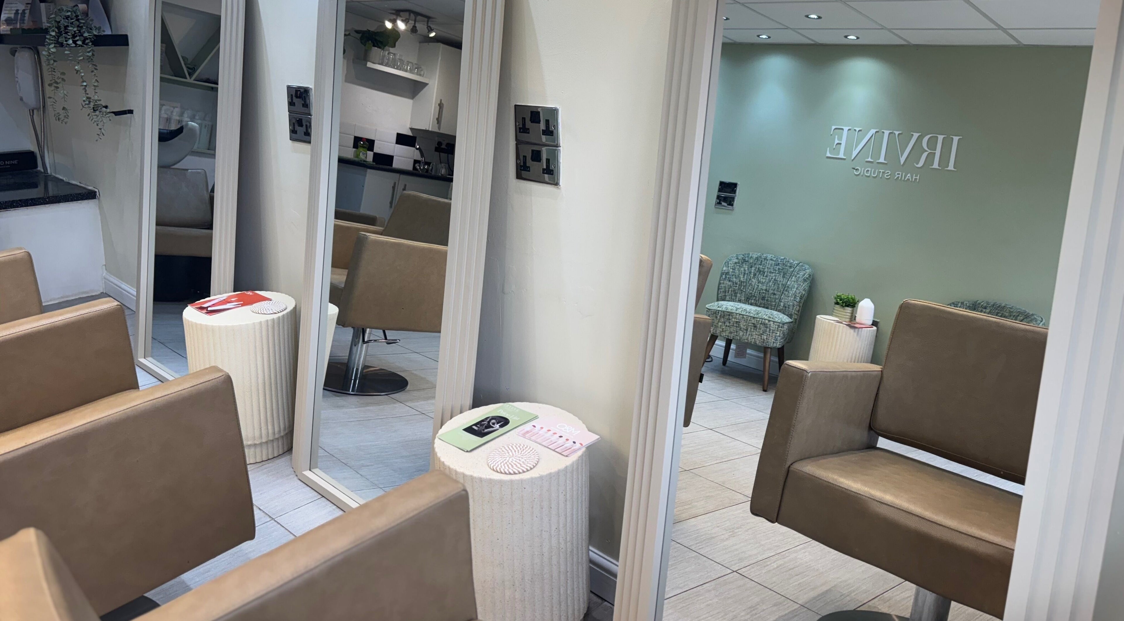 Interior view of Irvine Hair Studio in Bolton, England, GB, showcasing modern styling chairs and large mirrors.