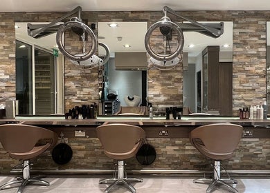 Modern salon interior at RYS Hair and Beauty in London, England, GB, featuring elegant styling chairs and mirrors.
