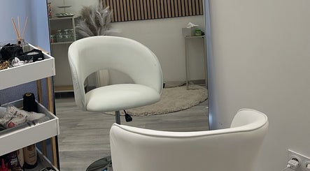 Intérieur élégant de KM BEAUTY HOUSE à Troyes, Grand Est, FR avec sièges blancs modernes.