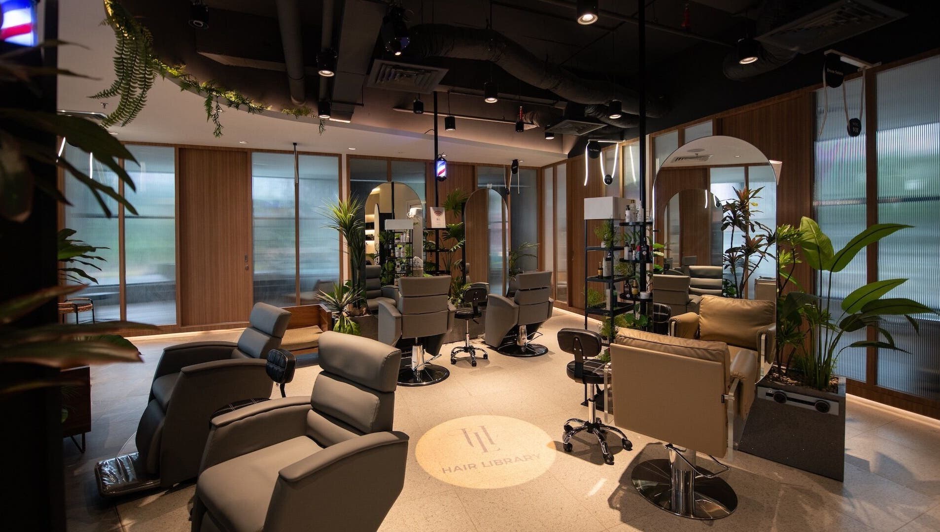 Luxurious salon interior at Snip & Drip, Petaling Jaya, Selangor, MY, featuring modern styling chairs and lush plants.