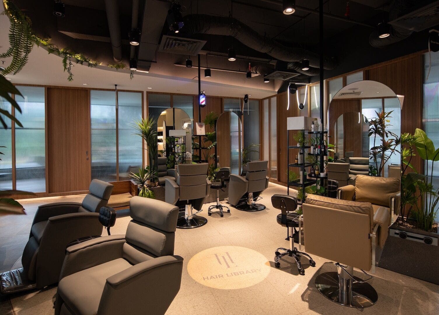 Luxurious salon interior at Snip & Drip, Petaling Jaya, Selangor, MY, featuring modern styling chairs and lush plants.