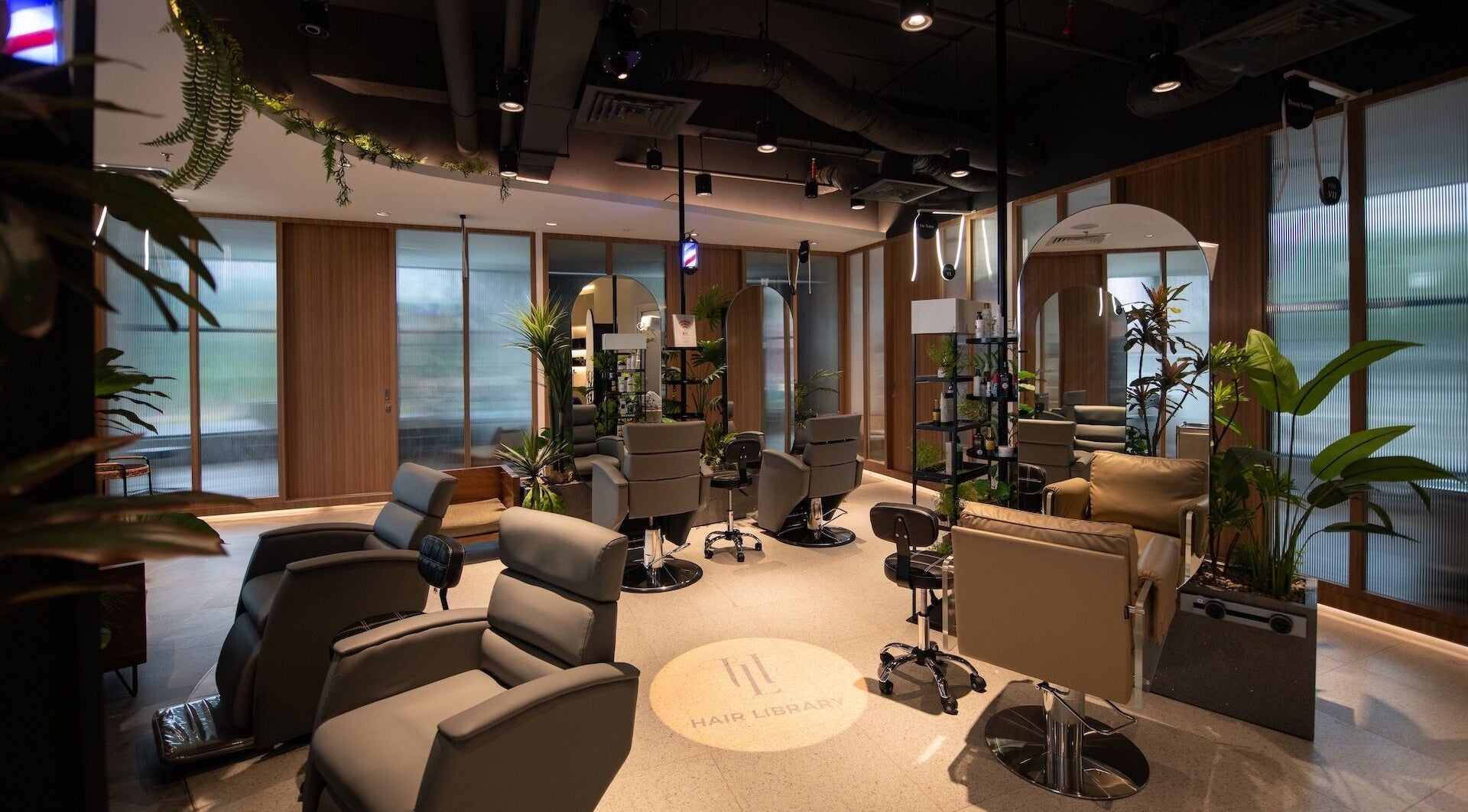 Luxurious salon interior at Snip & Drip, Petaling Jaya, Selangor, MY, featuring modern styling chairs and lush plants.