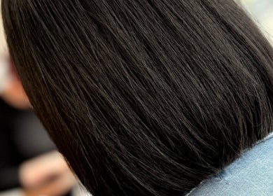 Close-up of a sleek bob haircut at JH Hair in Stalybridge, England, GB, showcasing glossy dark hair.
