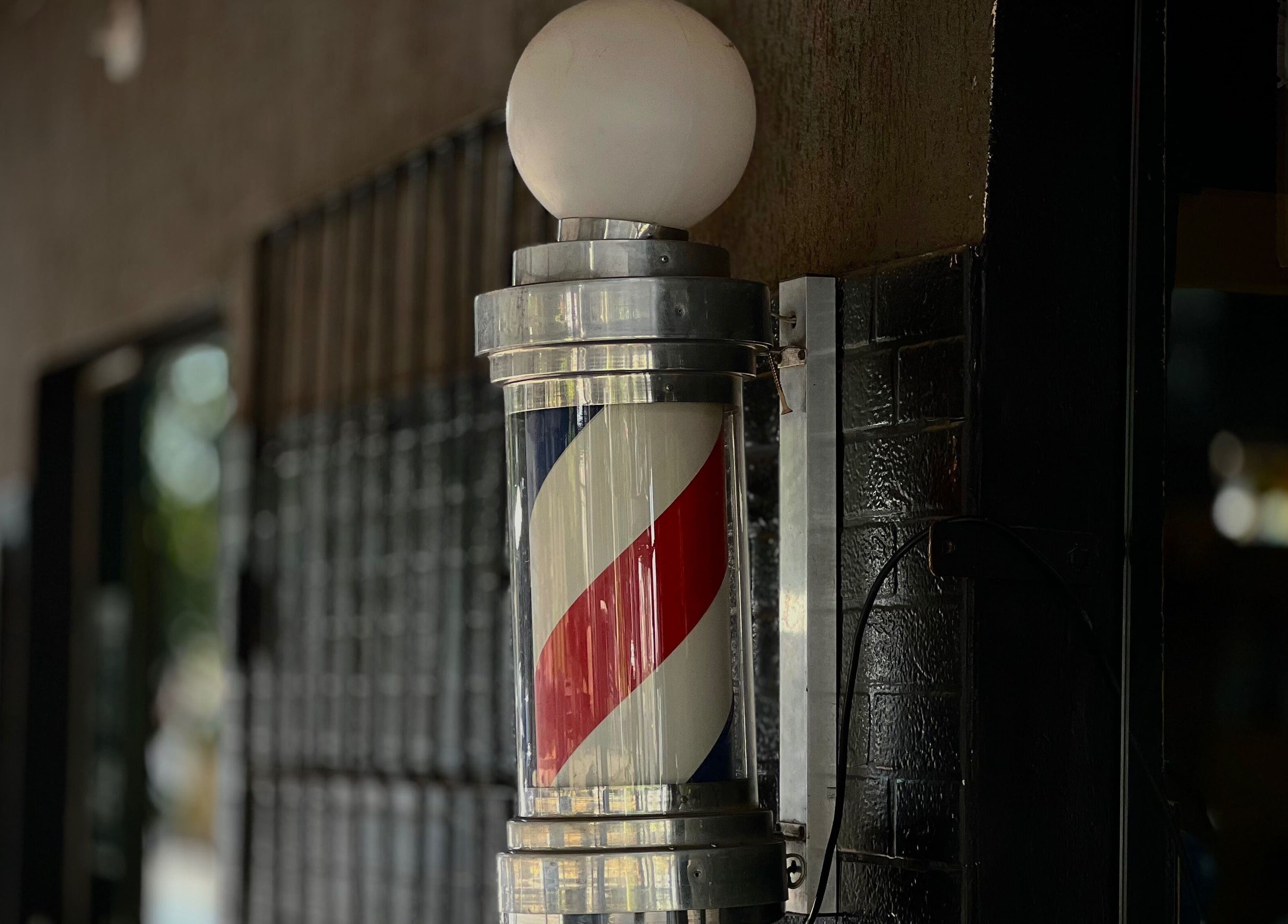 Faro clásico de barbero frente a Caballeros Barbería Casa Central en Luque, Central, PY.