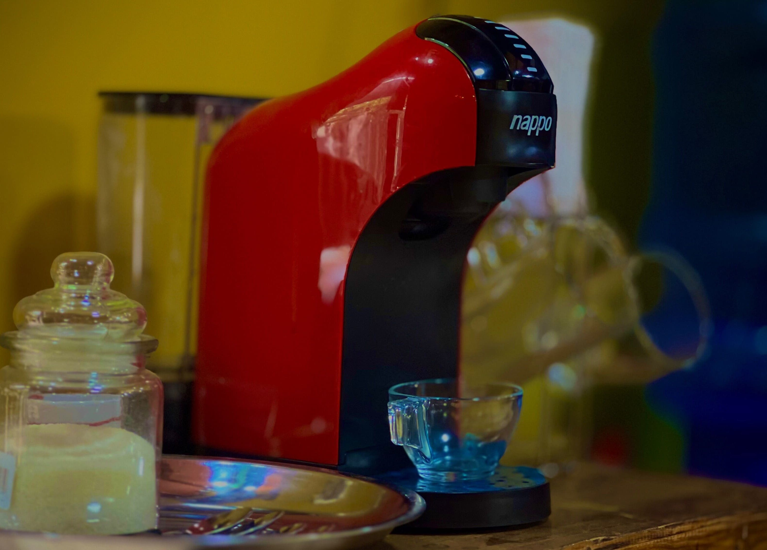 Cafetera roja y tazas en Caballeros Barbería Casa Central, Luque, Central, PY, ambiente cálido y acogedor.