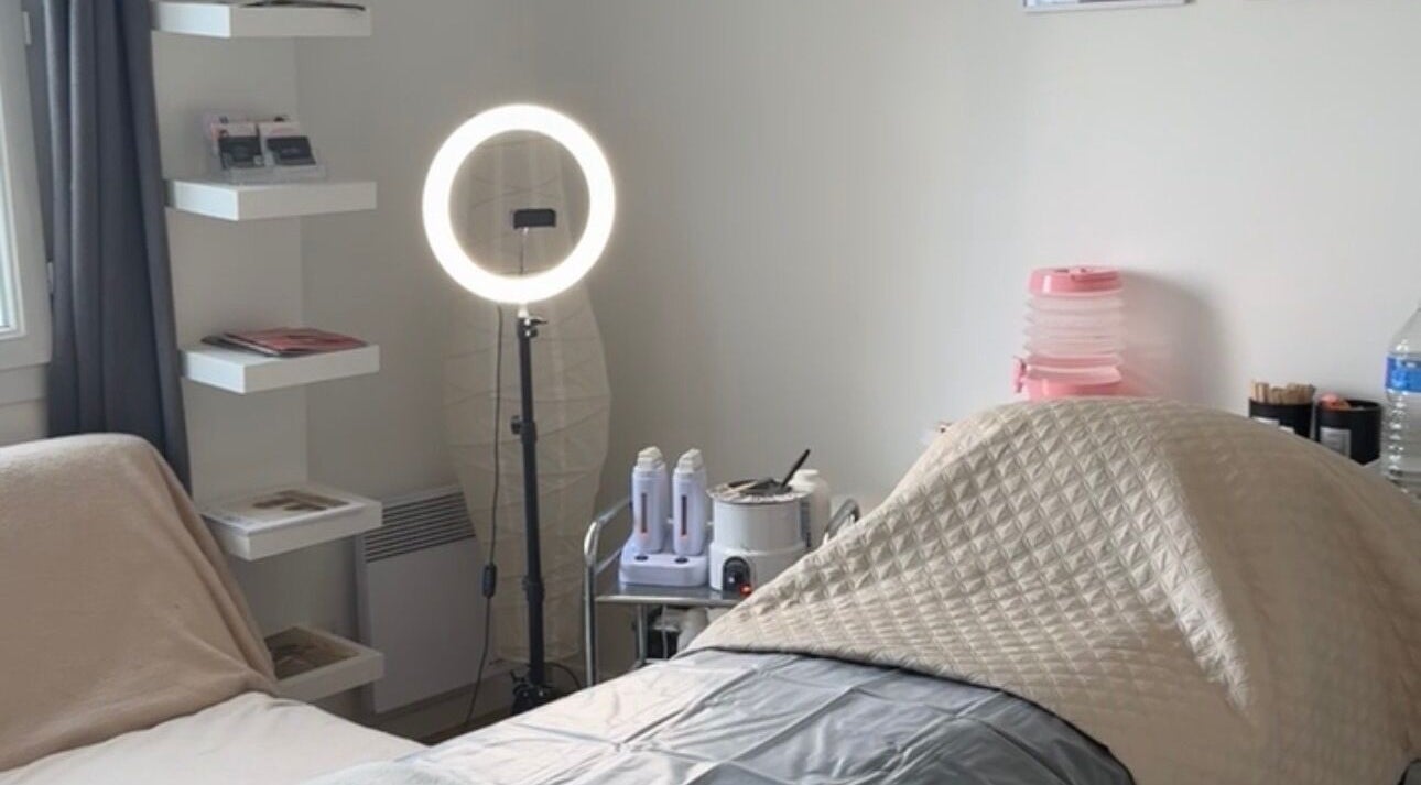 Cabine de soin moderne chez Honey Studio à Nemours, Île-de-France, FR avec anneau lumineux.