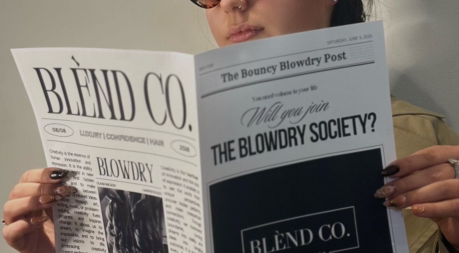 Person reading Blènd Co. newsletter in Stafford, England, GB salon setting.