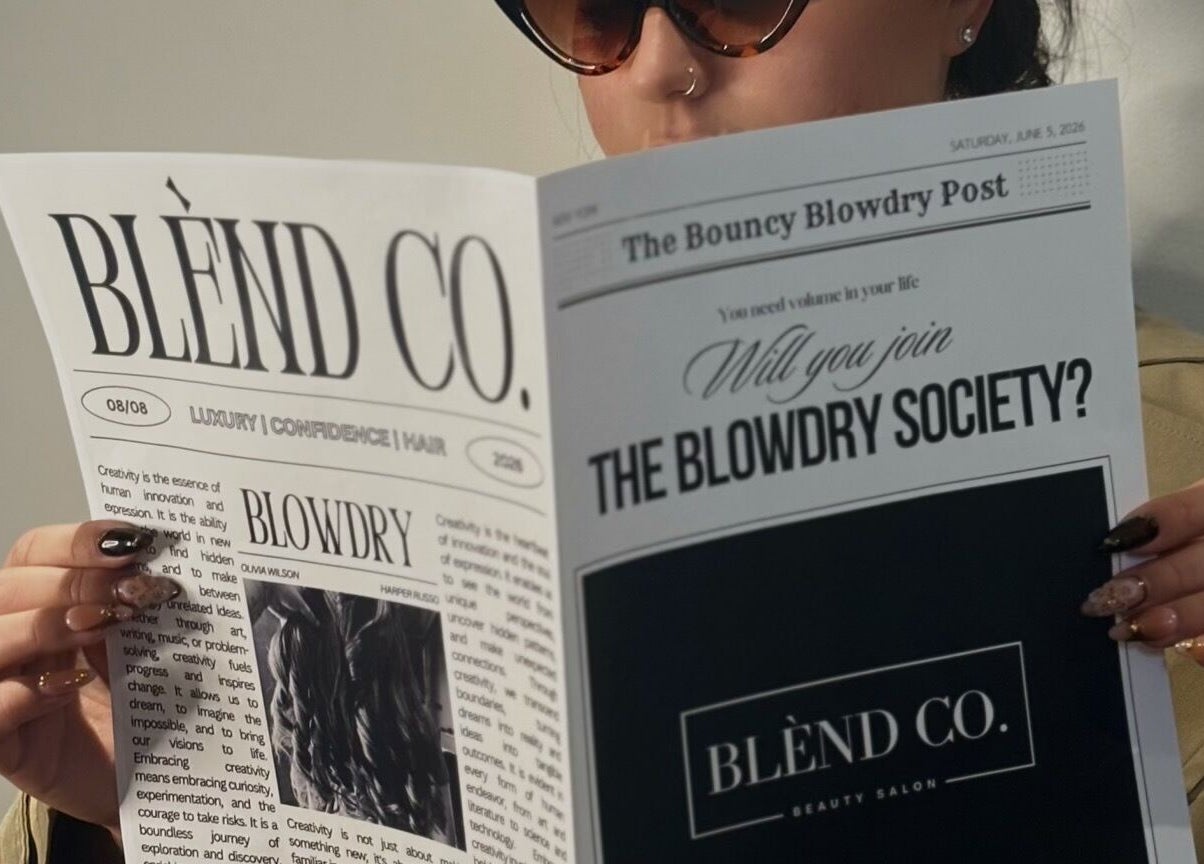 Person reading a Blènd Co. beauty newsletter in Stafford, England, GB, featuring the Blowdry Society.