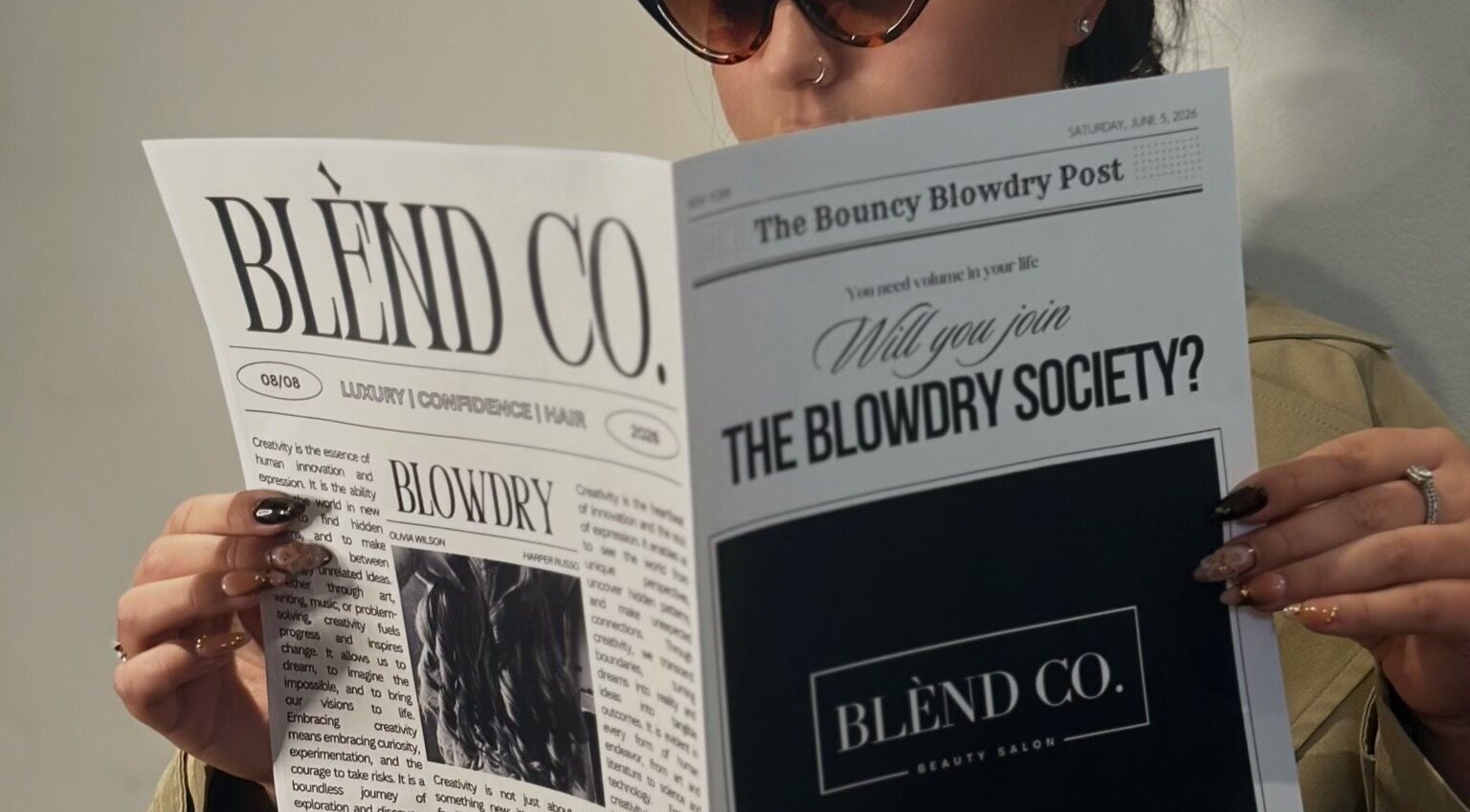 Person reading a Blènd Co. beauty newsletter in Stafford, England, GB, featuring the Blowdry Society.