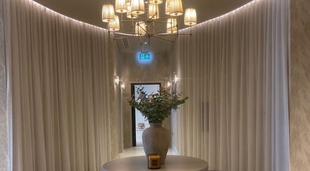 Sophisticated foyer at Exhale By Elegance, Stapleford, England, GB with chic chandeliers and a vase centerpiece.