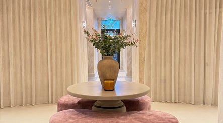 Elegant lobby at Exhale By Elegance, Stapleford, England featuring a vase on a round table with sheer curtains.