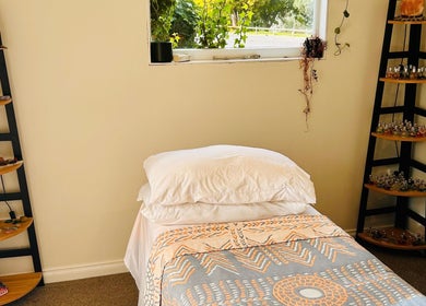 Relax in Threefold Wellness massage room, Waitara, Taranaki Region, NZ featuring a tranquil bed and essential oils.