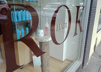 Window display at Rok Hair in Melbourne, Victoria, AU showcasing products inside a modern salon.