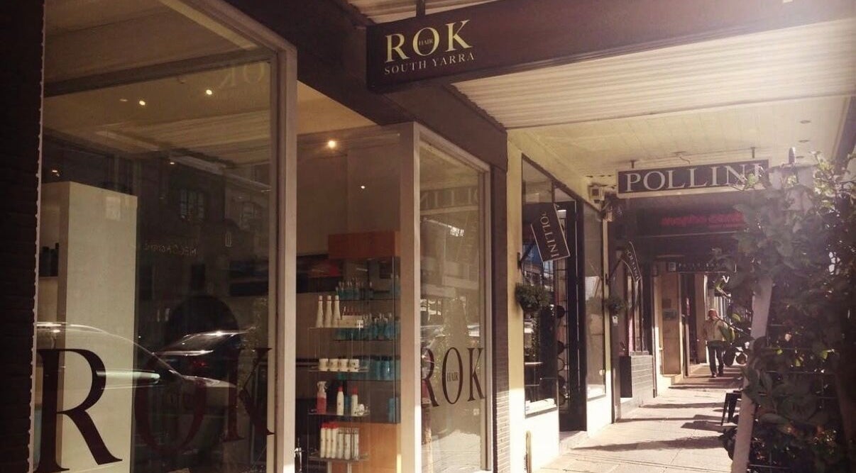 Exterior view of Rok Hair salon, Melbourne, Victoria, AU showcasing sleek glass windows and signage.