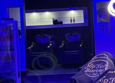 Modern interior of Top Fade Barbers, Melbourne, Victoria, AU. Features sleek seating and vibrant lighting.