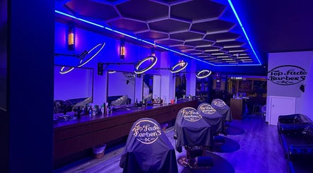 Interior of Top Fade Barbers in Melbourne, Victoria, AU with sleek neon lighting and modern barber chairs.