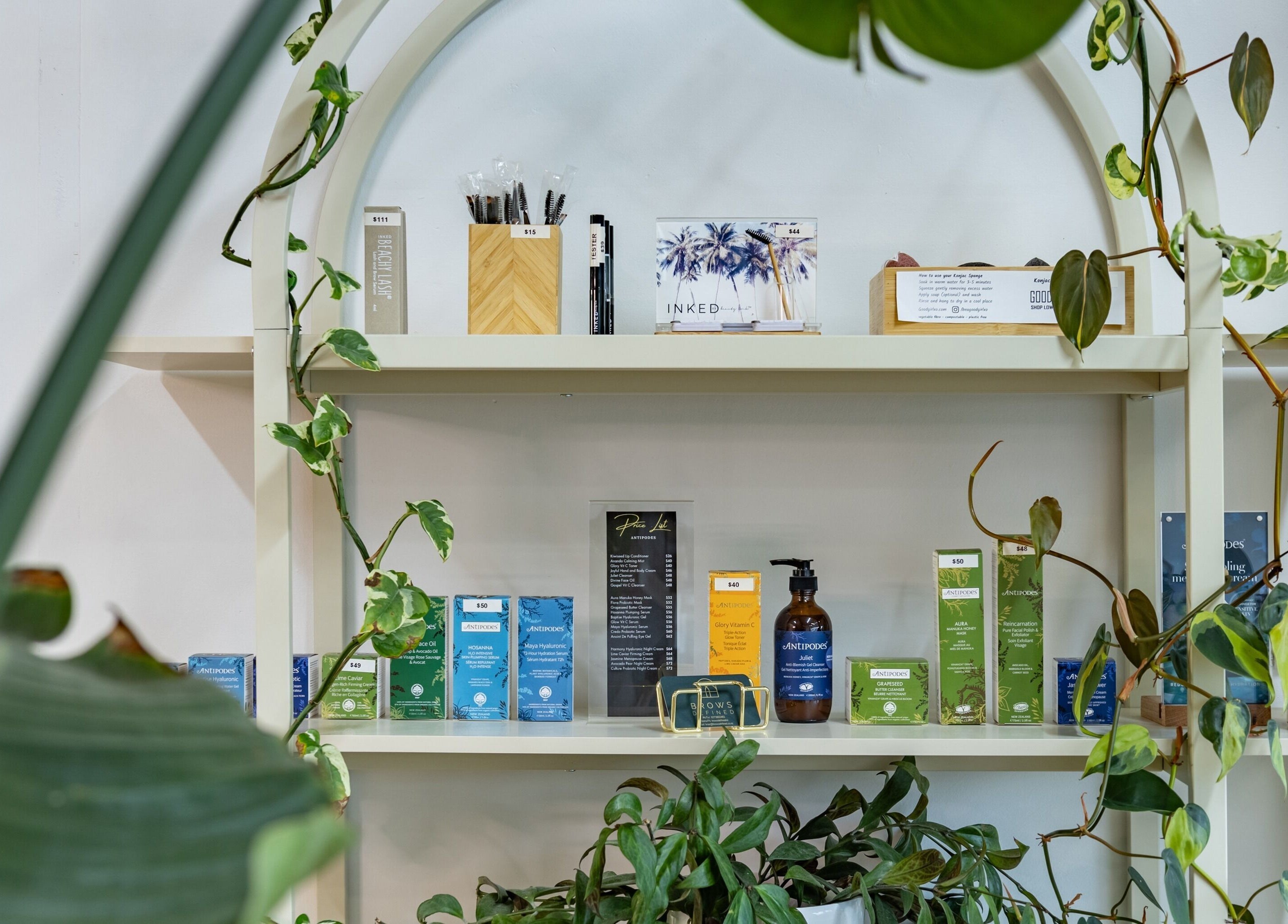 Wellness products on a lush green shelf at Brows Defined, Christchurch, Waitaha, NZ.