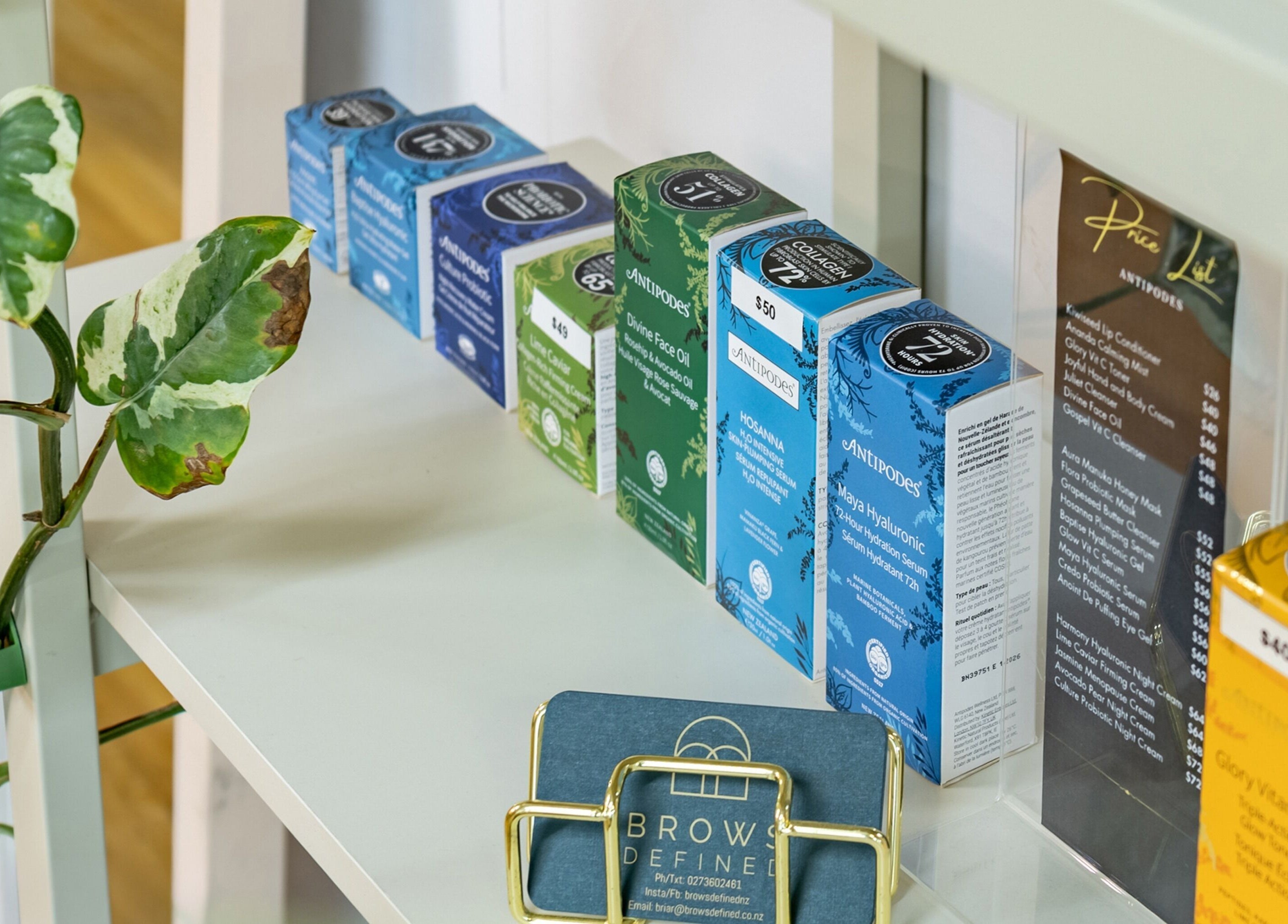 Product display at Brows Defined, Christchurch, Waitaha, NZ, showcasing skincare and business card.