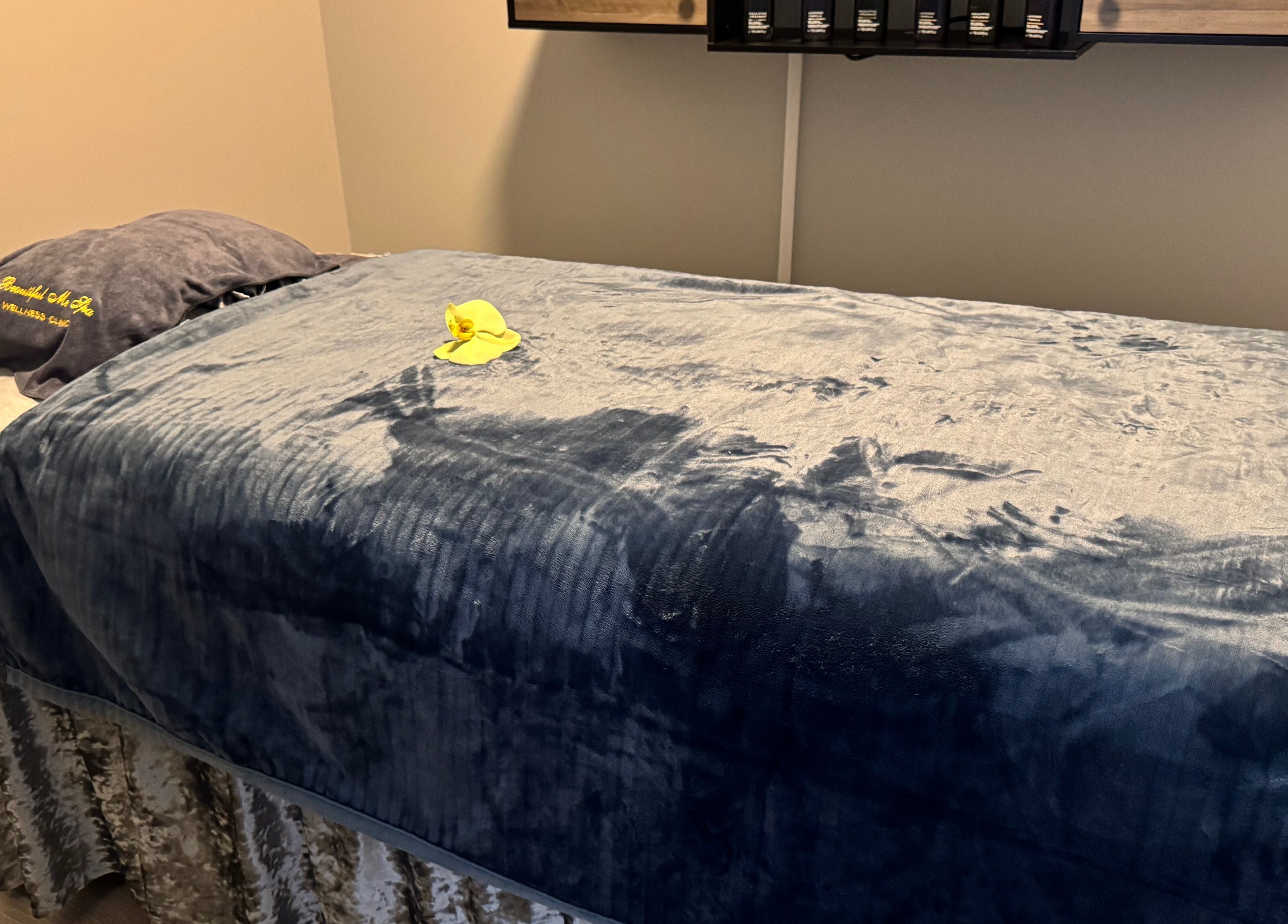 Relaxing spa treatment room at Beautiful Me Spa & Wellness Clinic, Toronto, Ontario, CA with plush blue bedding.