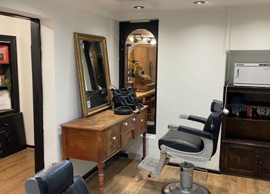 Vintage barber setup at Rudys Barbershop, St Helier, GB with chair and mirror.