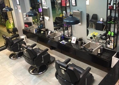 داخل Capital Barber في عمّان، عبدون، محافظة العاصمة، JO يظهر كراسي حلاقة أنيقة ومرايا عملية.