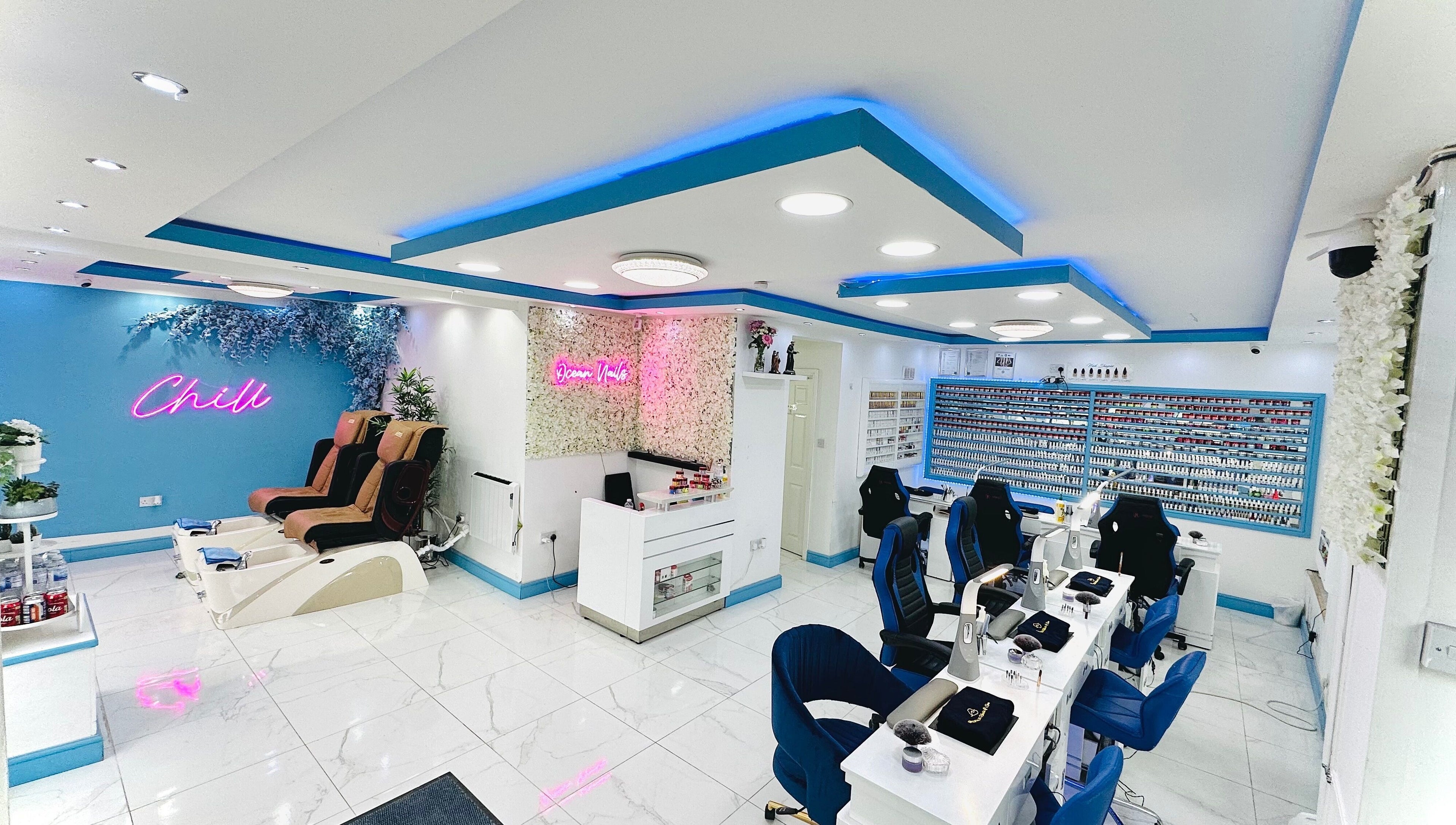 Bright, modern interior of Ocean Nails spa in Airdrie, Scotland, GB with vibrant decor and luxurious seating.