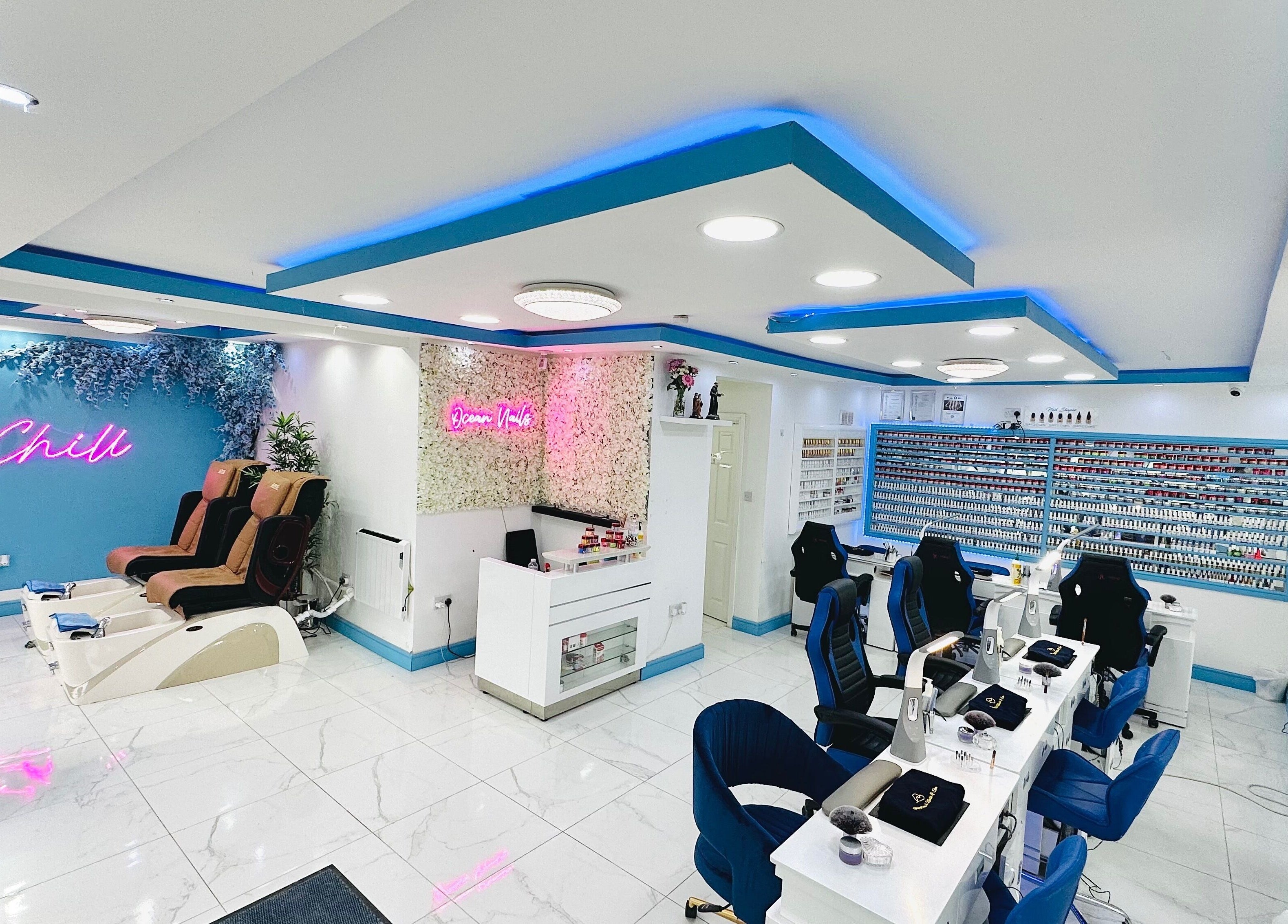 Bright, modern interior of Ocean Nails spa in Airdrie, Scotland, GB with vibrant decor and luxurious seating.