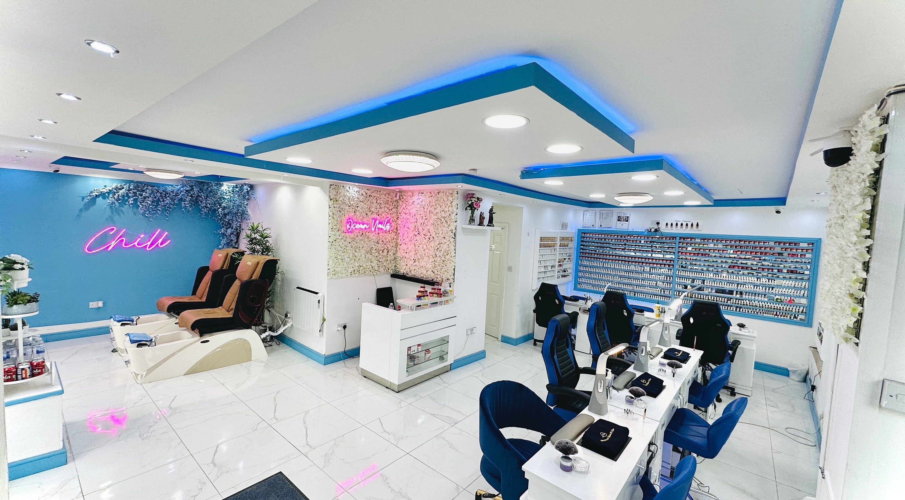 Bright, modern interior of Ocean Nails spa in Airdrie, Scotland, GB with vibrant decor and luxurious seating.