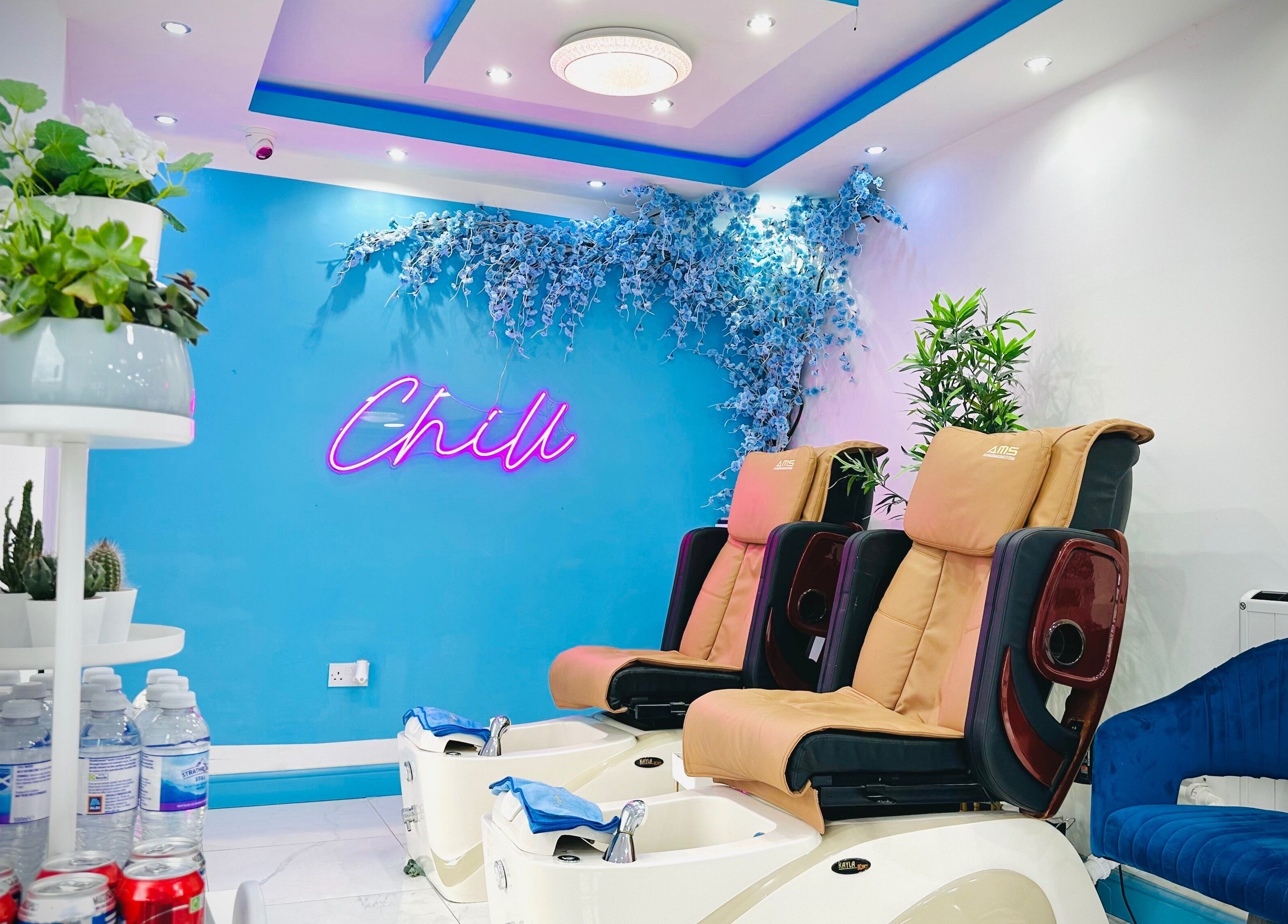 Relaxing pedicure chairs at Ocean Nails spa, Airdrie, Scotland, GB with a vibrant 'Chill' neon sign.
