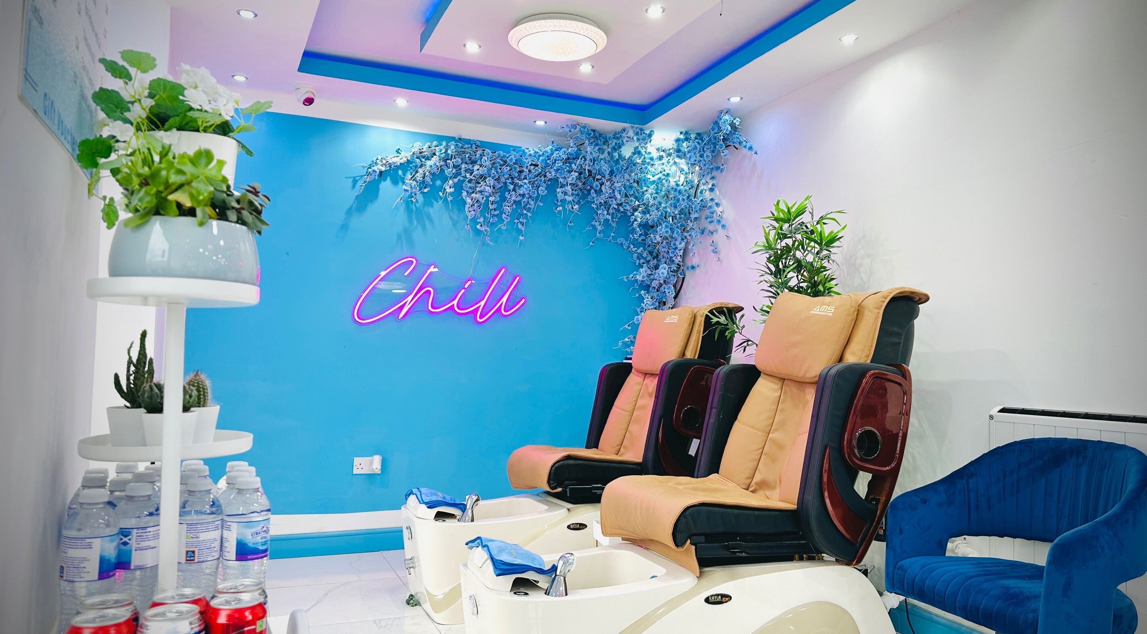 Relaxing pedicure chairs at Ocean Nails spa, Airdrie, Scotland, GB with a vibrant 'Chill' neon sign.