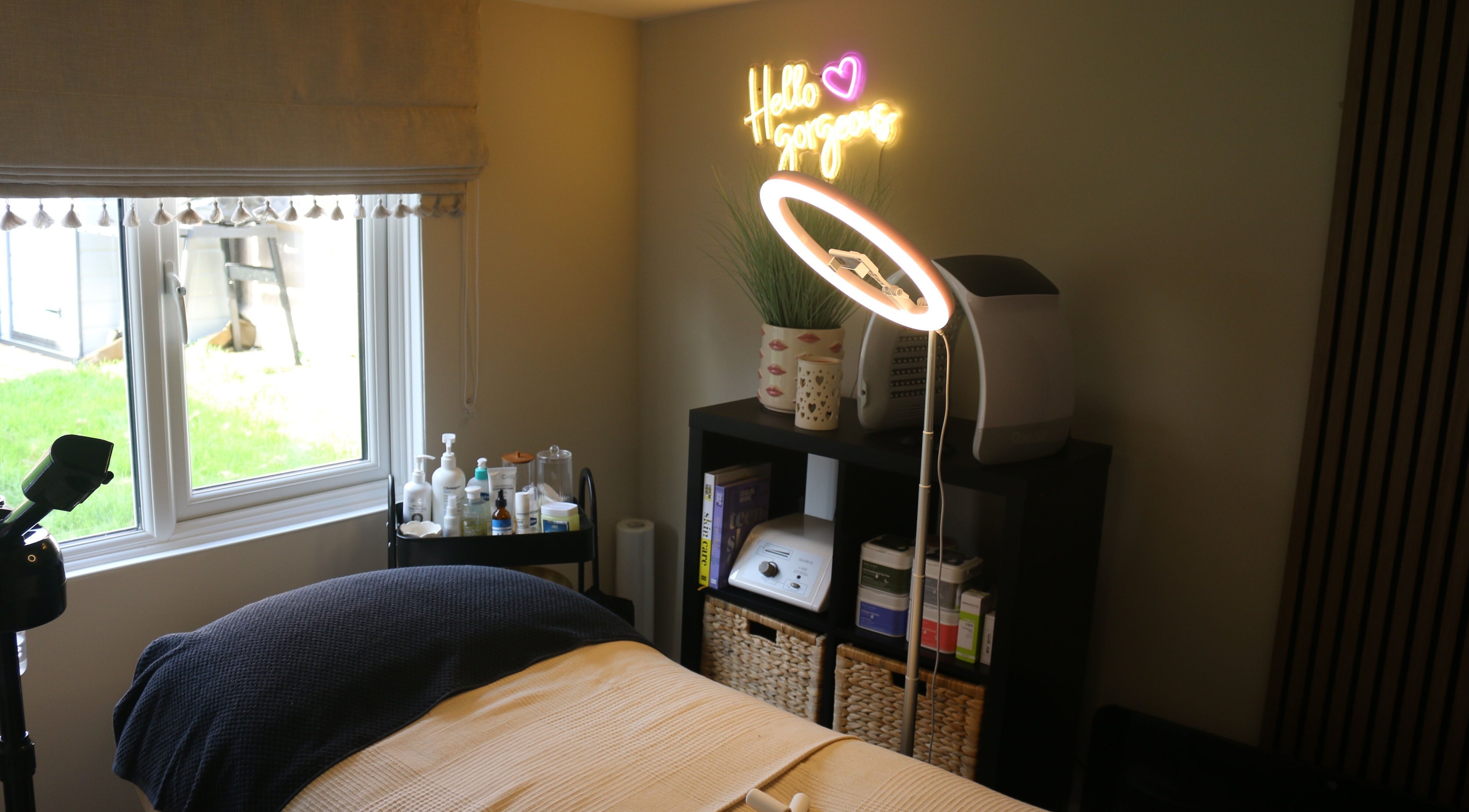 Cozy treatment room at Face Lounge in Bidford-on-Avon, England, GB with a neon sign and elegant decor.