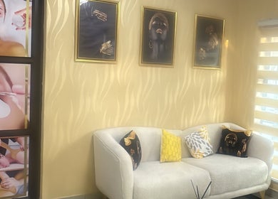 Relaxing seating area at Glamour Haven Beauty, Johannesburg, Gauteng, ZA with elegant wall art and plush sofa.
