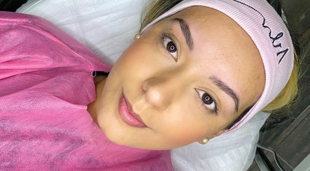 Cliente sorridente após tratamento de beleza na NV Beauty, Tomar, Santarém, PT, usando faixa rosa.