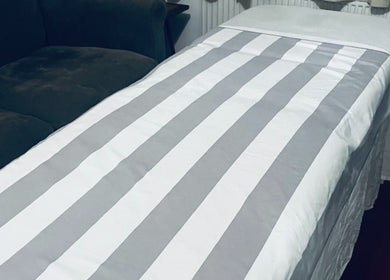 Cozy treatment bed at Peak Recovery Sports Therapy, Frampton Cotterell, England, GB ready for relaxation.