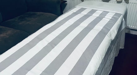 Cozy treatment bed at Peak Recovery Sports Therapy, Frampton Cotterell, England, GB ready for relaxation.