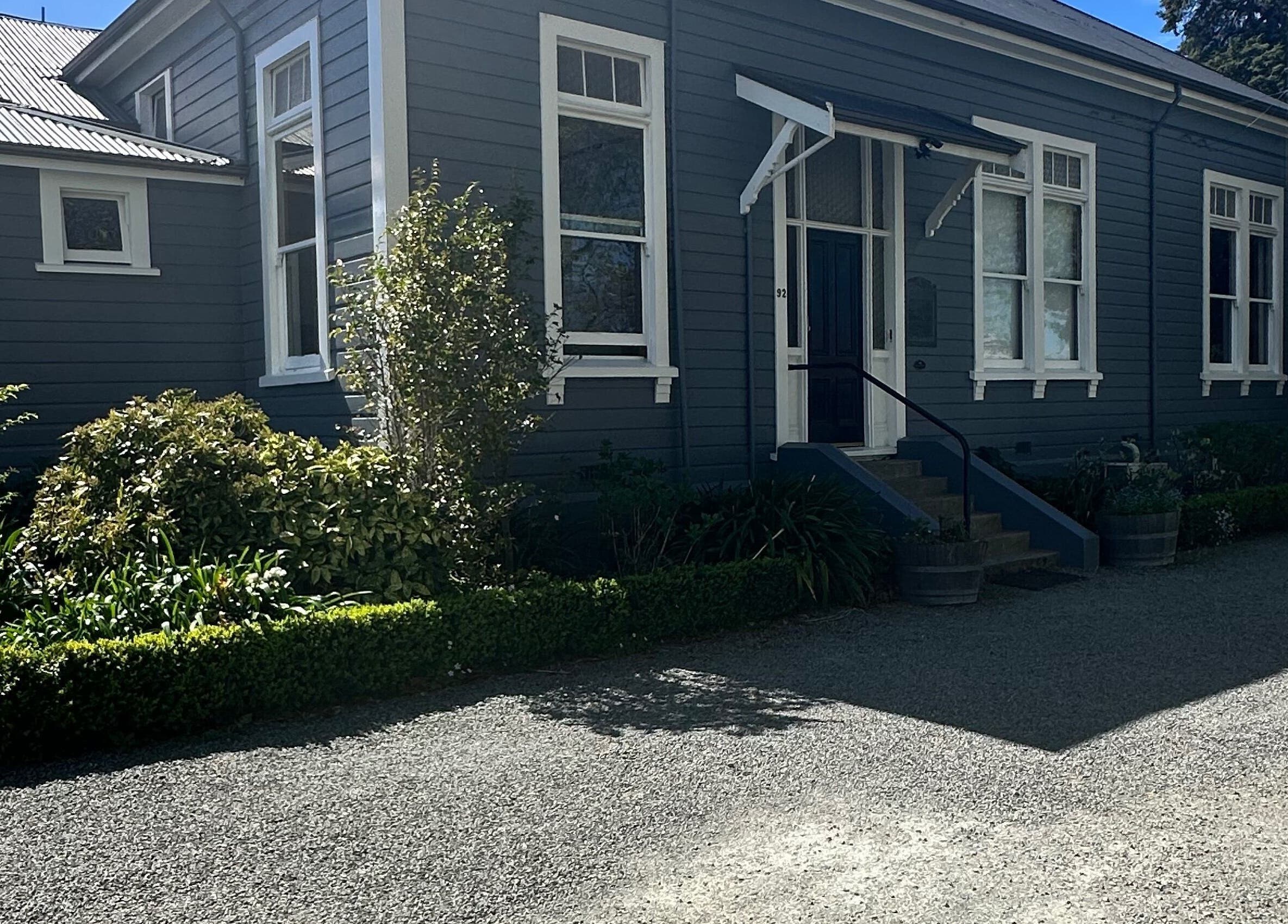 Front view of Alchemy Hair & Beauty in Blenheim, Marlborough Region, NZ with lush greenery.