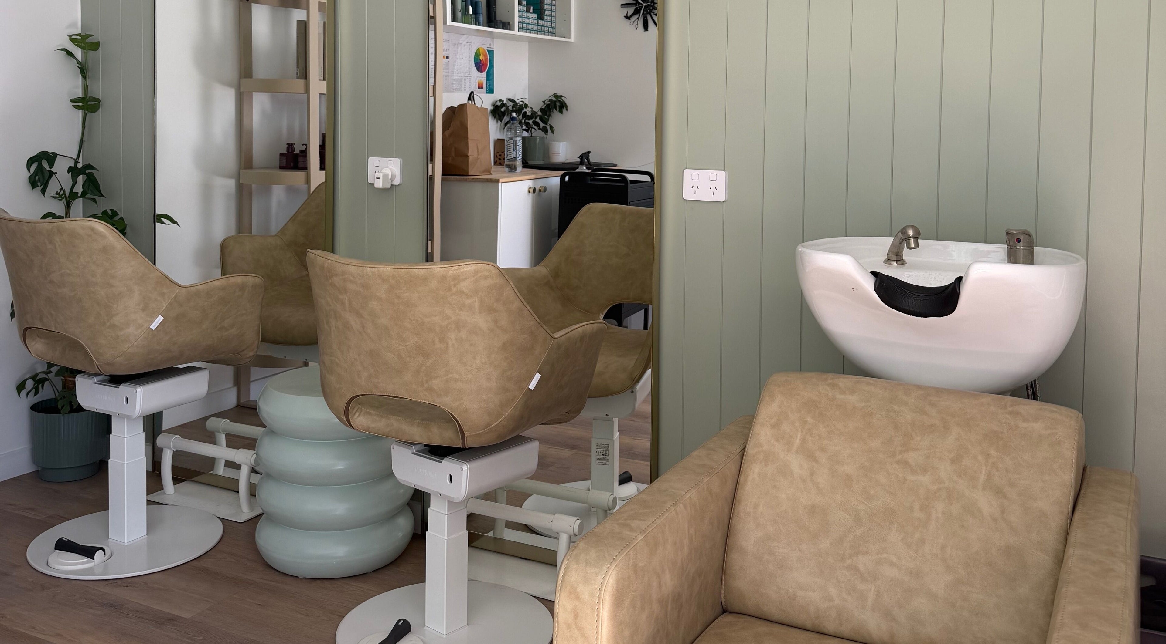 Stylish salon chairs facing mirrors at Alchemy Hair & Beauty, Blenheim, Marlborough Region, NZ.