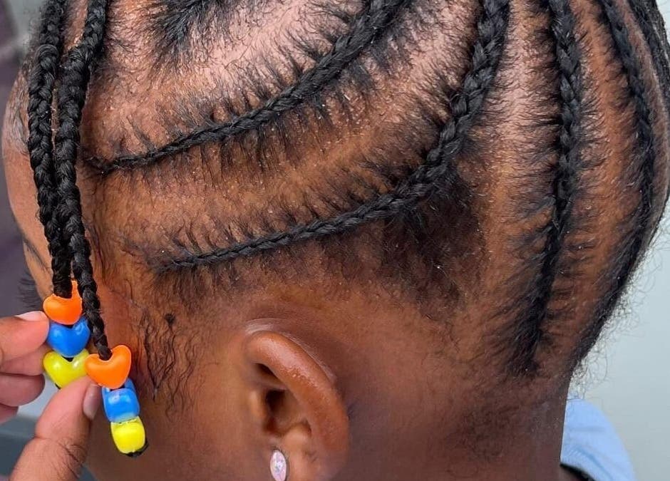Intricate braided hairstyle with colorful beads at Nthaby Pretty Kids Salon, Pretoria East, Gauteng, ZA.