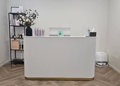 Reception area at Cascade Hair Extensions, Mount Warren Park, Queensland, featuring a sleek white desk and product display.