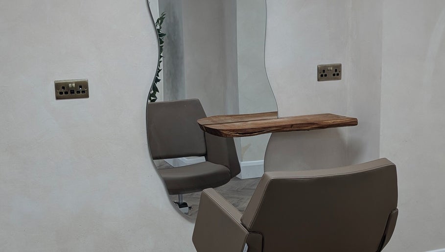 Elegant styling chair at IzTrueMUA, Masham, England, GB, framed by a unique wavy mirror.