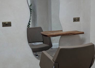 Elegant styling chair at IzTrueMUA, Masham, England, GB, framed by a unique wavy mirror.