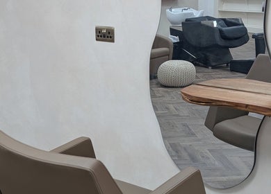 Contemporary salon interior at IzTrueMUA, Masham, England, GB, featuring sleek chairs and a stylish wooden mirror.