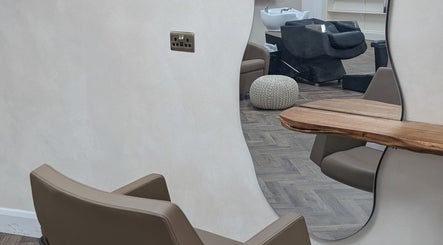 Contemporary salon interior at IzTrueMUA, Masham, England, GB, featuring sleek chairs and a stylish wooden mirror.