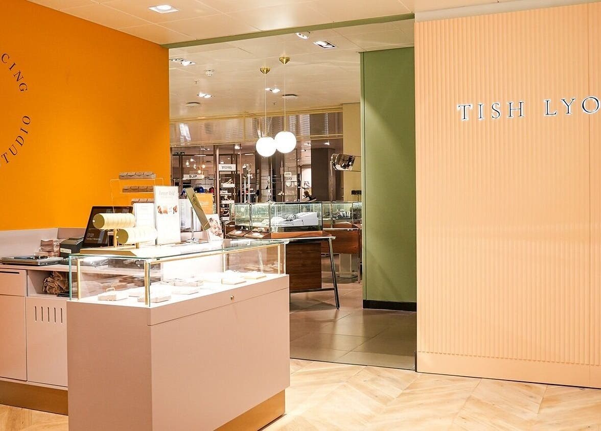Inside Tish Lyon, London, England, GB: chic, modern piercing studio with bright orange and green accents.