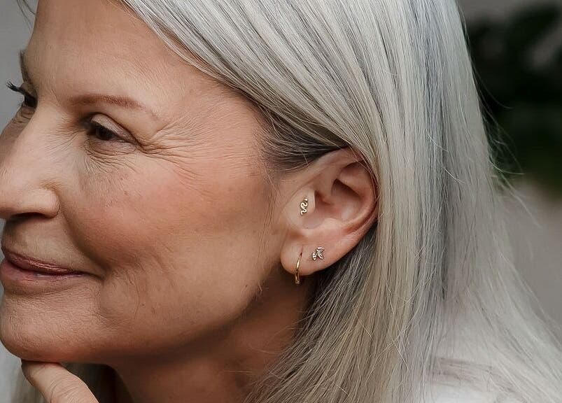 Close-up of an elegant woman with silver hair and delicate earrings at Tish Lyon, London, England, GB.