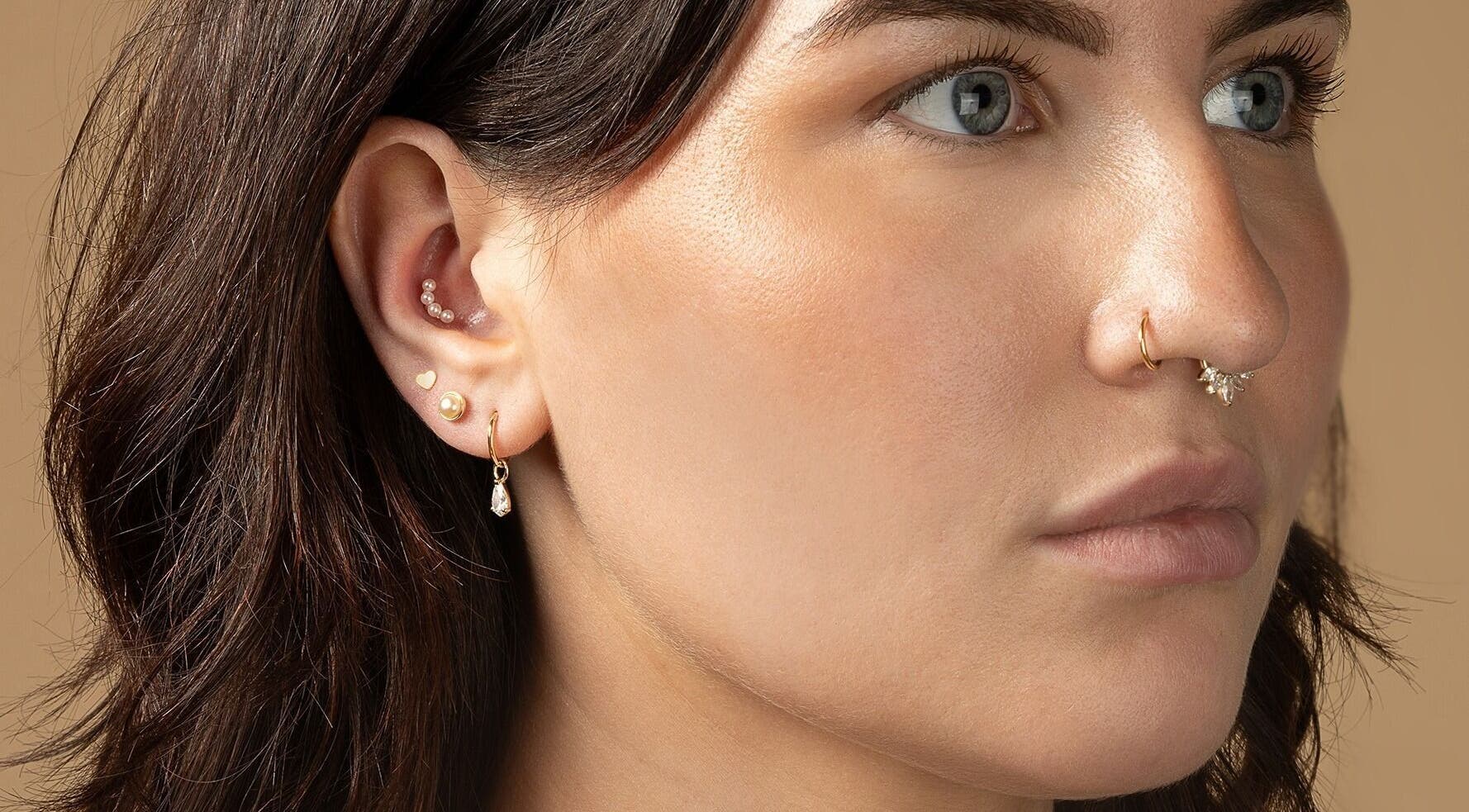 Close-up of ear and nose piercings at Tish Lyon Luxury Piercing & Jewellery Studio - Bluewater, Dartford, England, GB.