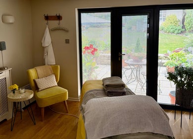 Tranquil treatment room at Katherapyuk, Crowmarsh Gifford, England, GB with a cozy chair and garden view.