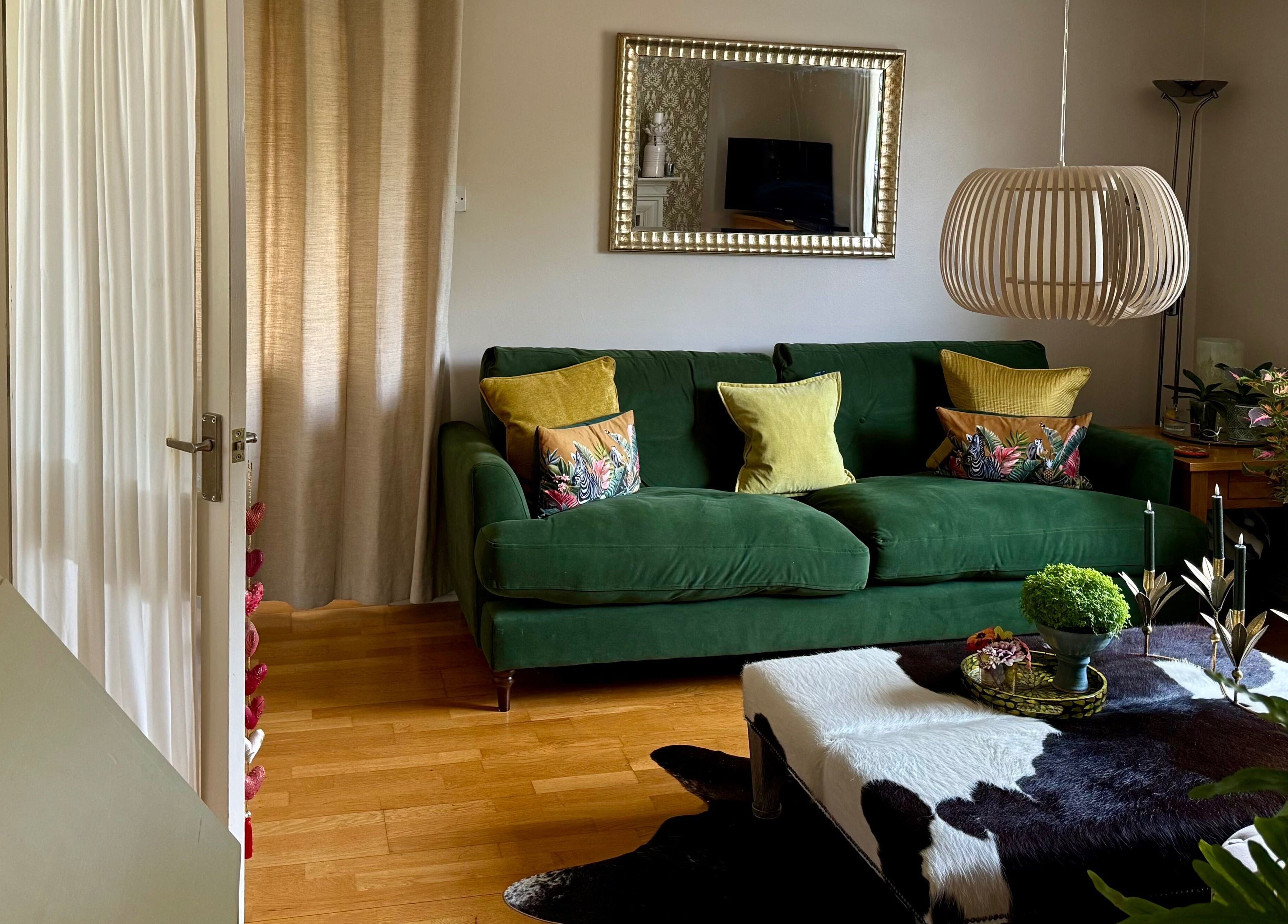 Cozy green sofa in Katherapyuk, Crowmarsh Gifford, England, GB with chic decor and a soft rug.